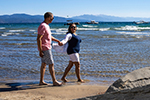 Two people walking on the beach at Lake Tahoe
