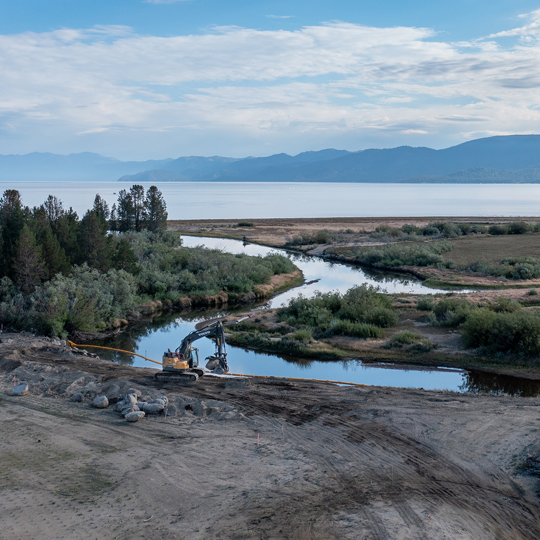 Excavator along the Upper Truckee River with Lake Tahoe in background