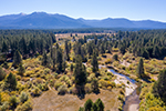 Aerial view of the acquisition in South Lake Tahoe, with the Upper Truckee River in the foreground and mountains in the background.