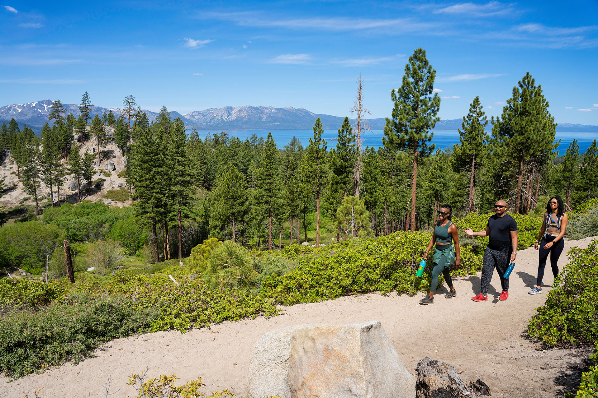 People enjoying a hiking trail at Van Sickle Bi-State Park, with Lake Tahoe in the background.