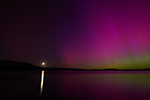 The aurora and the moon shine on Lake Tahoe in May 2024.