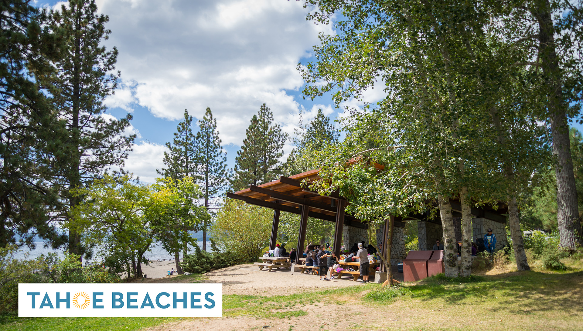 People enjoying a picnic area at North Tahoe Beach on Conservancy land at Lake Tahoe, with the logo for the Tahoe Public Beaches website.