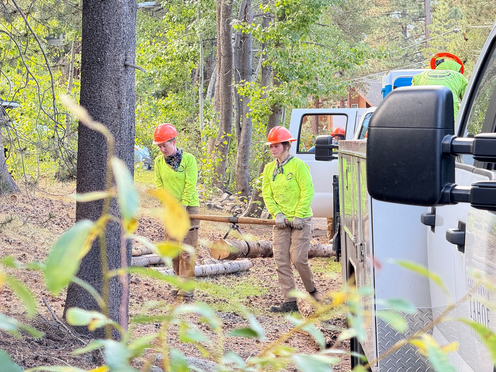 Crew members carrying fence poles