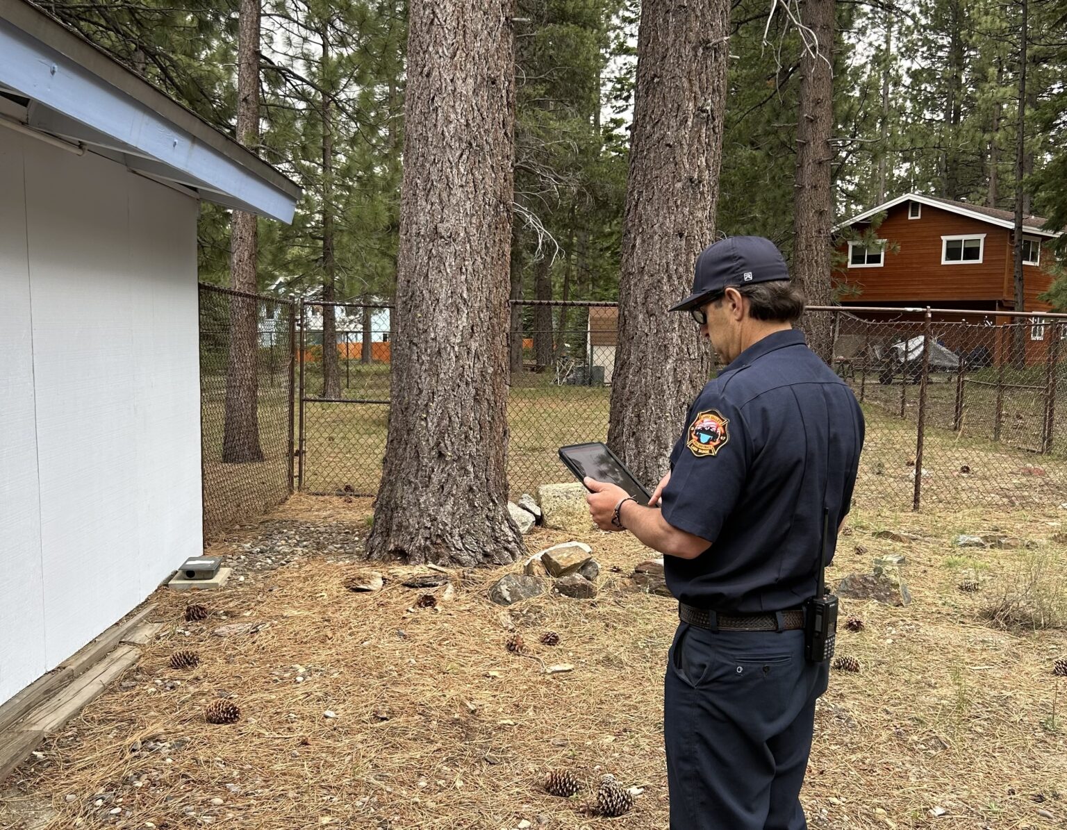 Firefighter conducting a defensible space inspection at a home using FireAside technology.